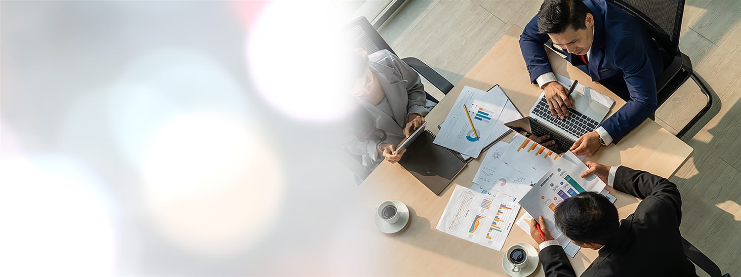 A team working around a table with charts and papers